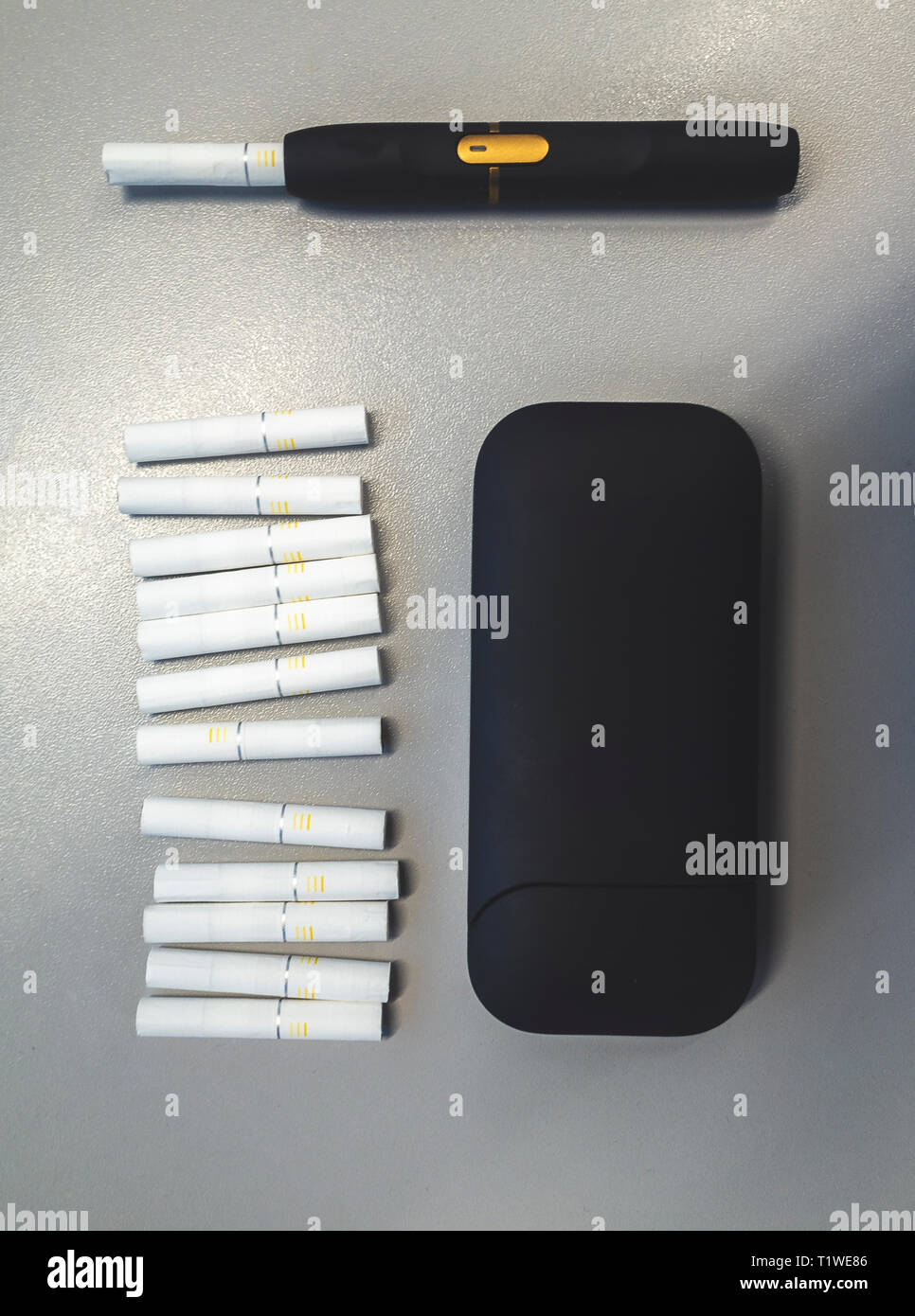 Tobacco heating system and a pack of tobacco sticks on a gray background  Stock Photo
