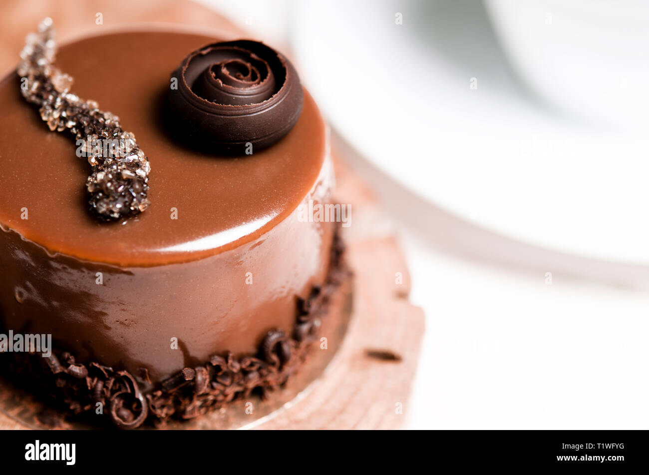 A Delicious Chocolate Cake With Chocolate Pieces Lies On A Wooden