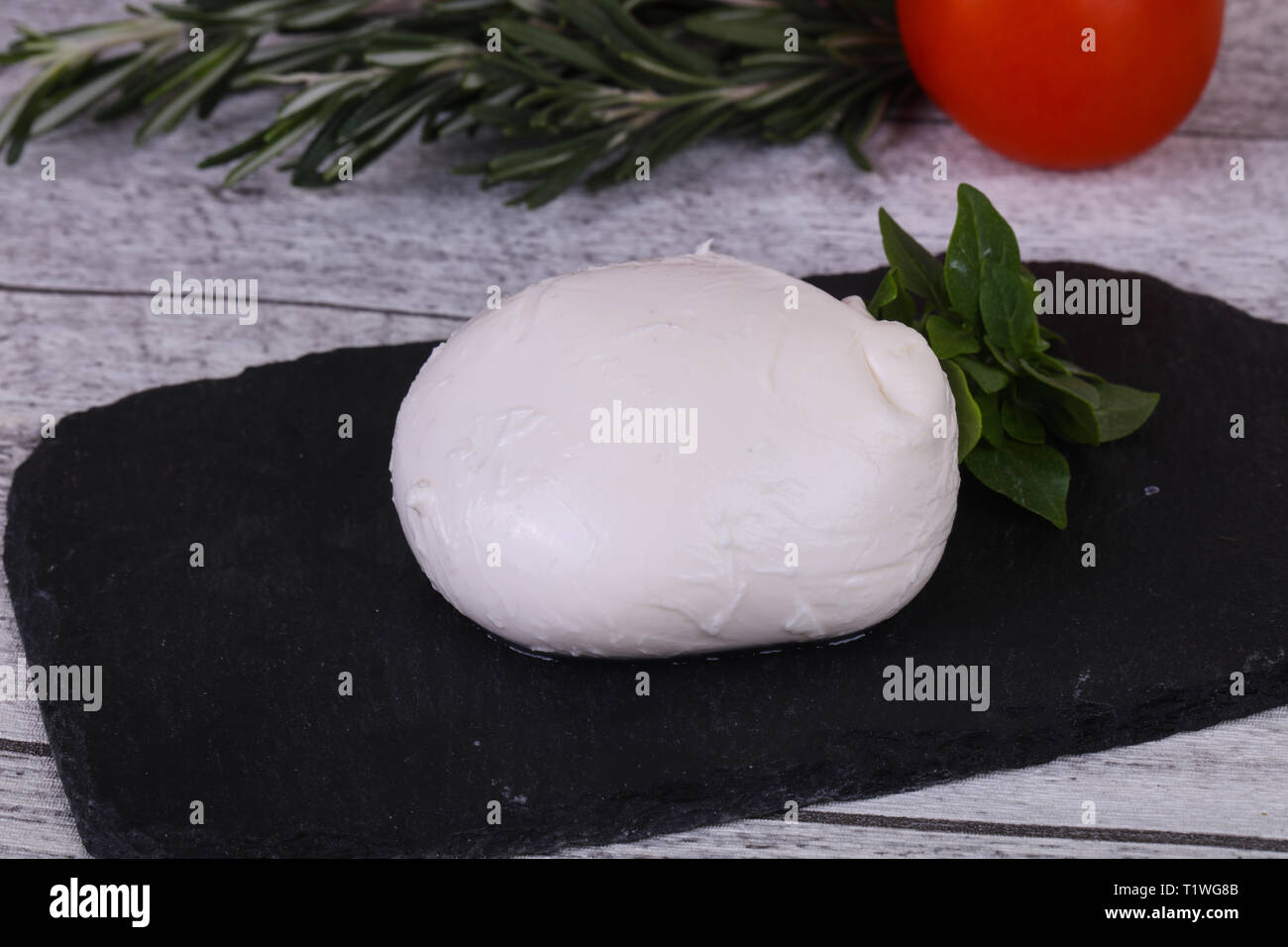 Italian Mozzarella cheese ball served basil and tomatoes Stock Photo