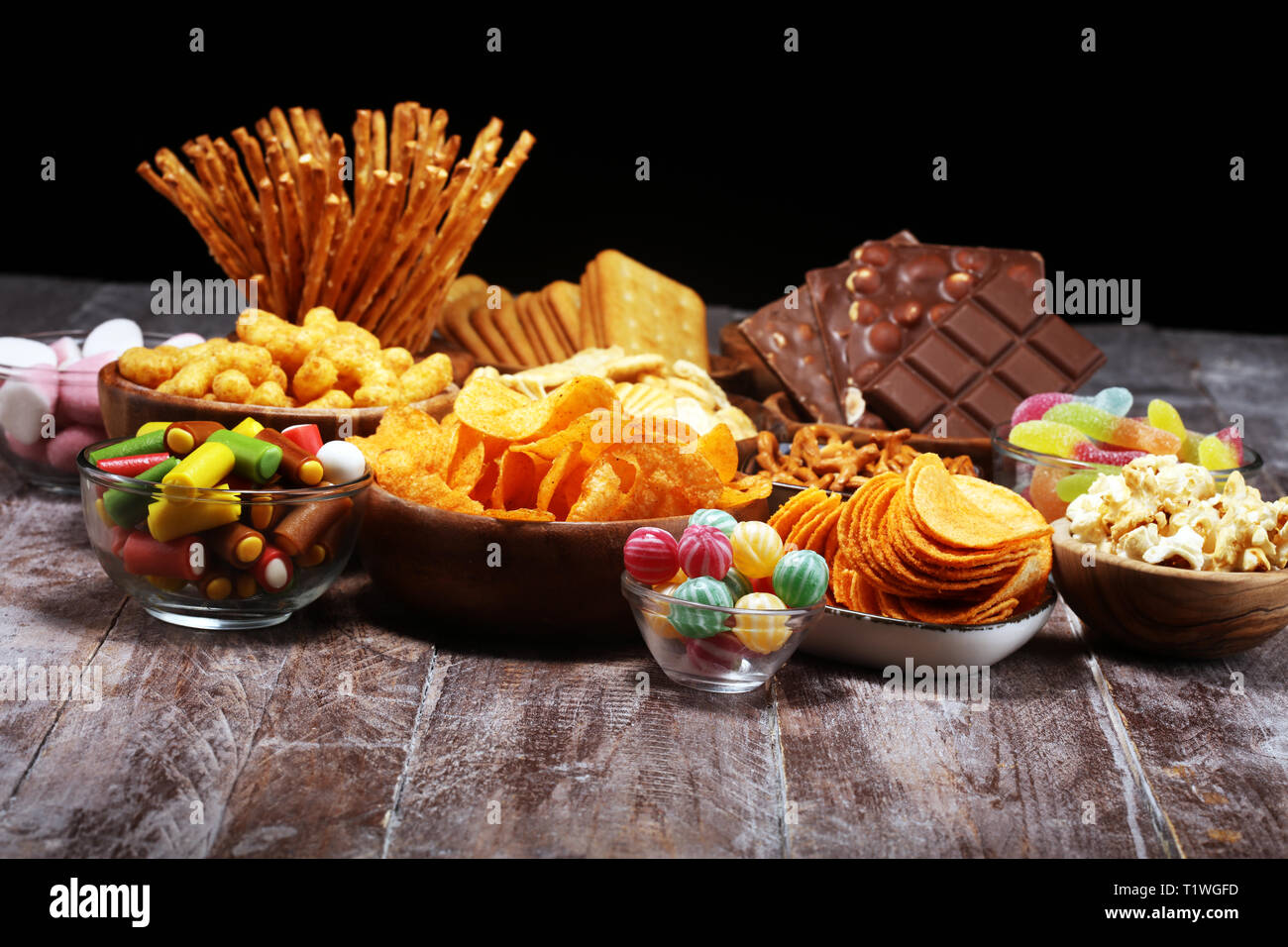 Salty snacks. Pretzels, chips, crackers in wooden bowls. Unhealthy