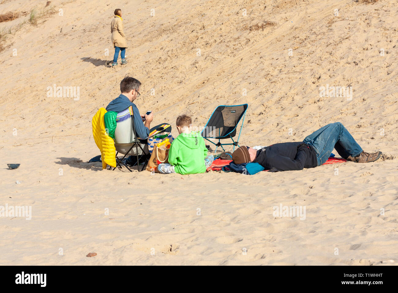A family sitting and relaxing on the beach at Formby, Merseyside, UK Stock Photo