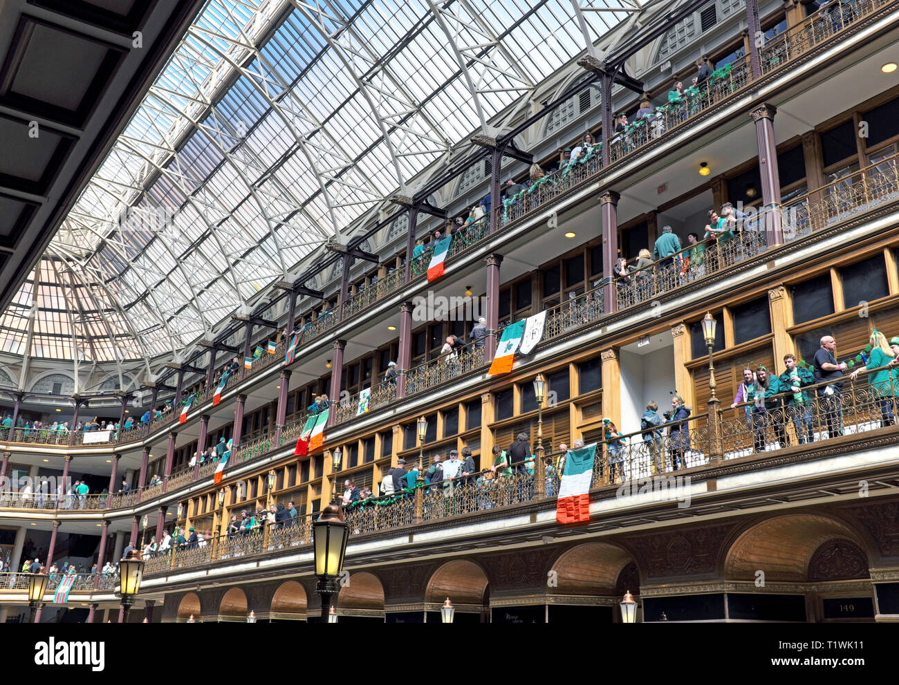 St. Patrick's Day celebrants enjoy the organic indoor 'street' party in the Arcade, a historic indoor mall with hotel in downtown Cleveland, Ohio, USA. Stock Photo