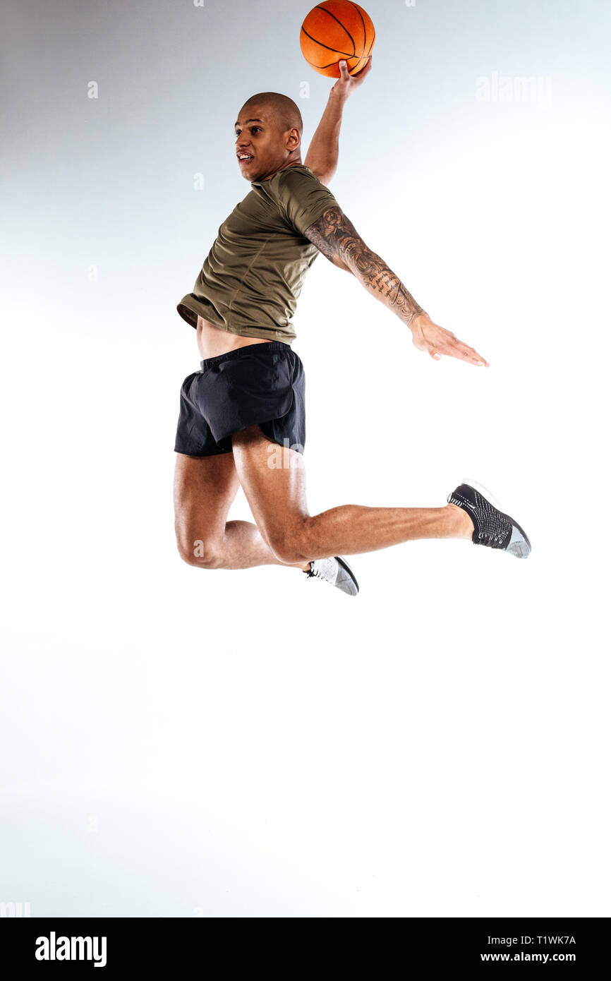 Basketball player jumping high holding a ball Stock Photo Alamy