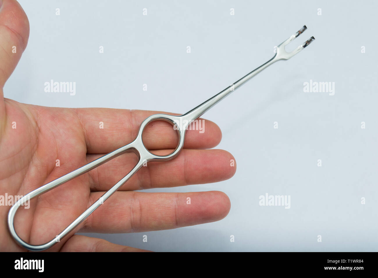 Volkman Retractor with two prongs in the human hand Stock Photo - Alamy