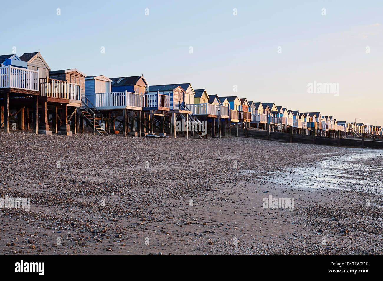 Beach huts by the coast with waves coming into the shore in Southend On Sea Stock Photo