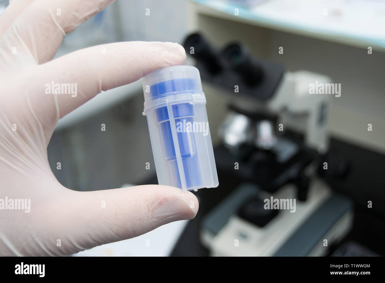 laboratory worker holding in his hand a bottle for feces samples Stock ...