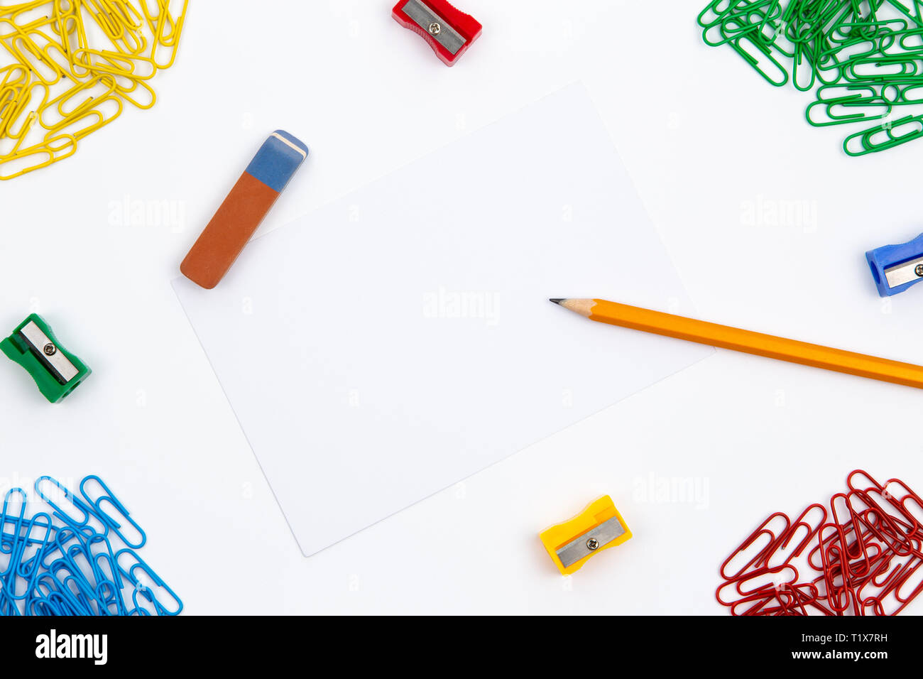 Pencil, eraser, sharpener, paper clips lie in different angles of the