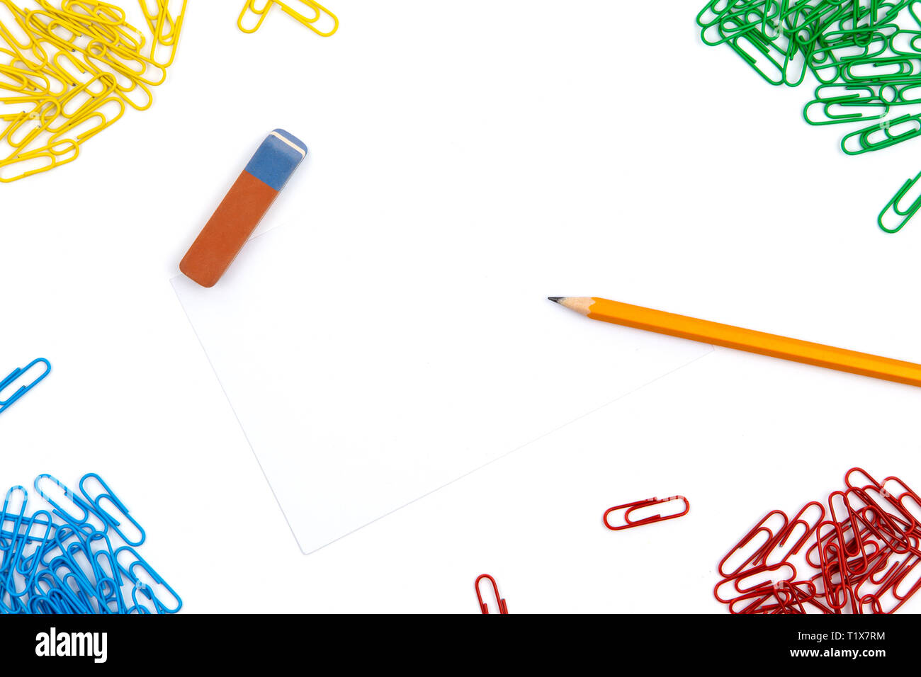 Pencil, eraser, paper clips lie in different angles of the sheet on a