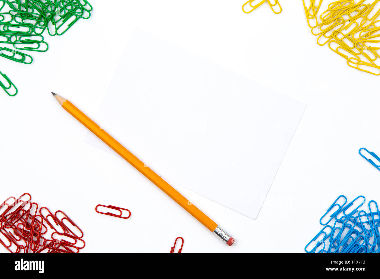 Pencil, paper clips lie in different angles of the sheet on a white ...