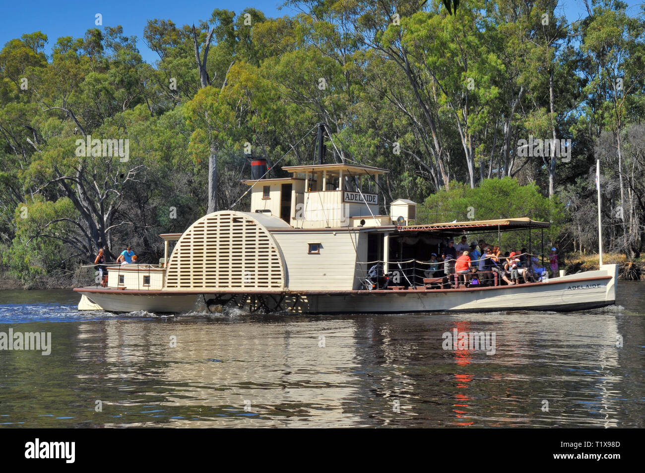 Restored paddle steamer 'Adelaide' on the Adelaide River in South Australia. Passengers on deck, Eucalyptus trees at rivers edge. Stock Photo