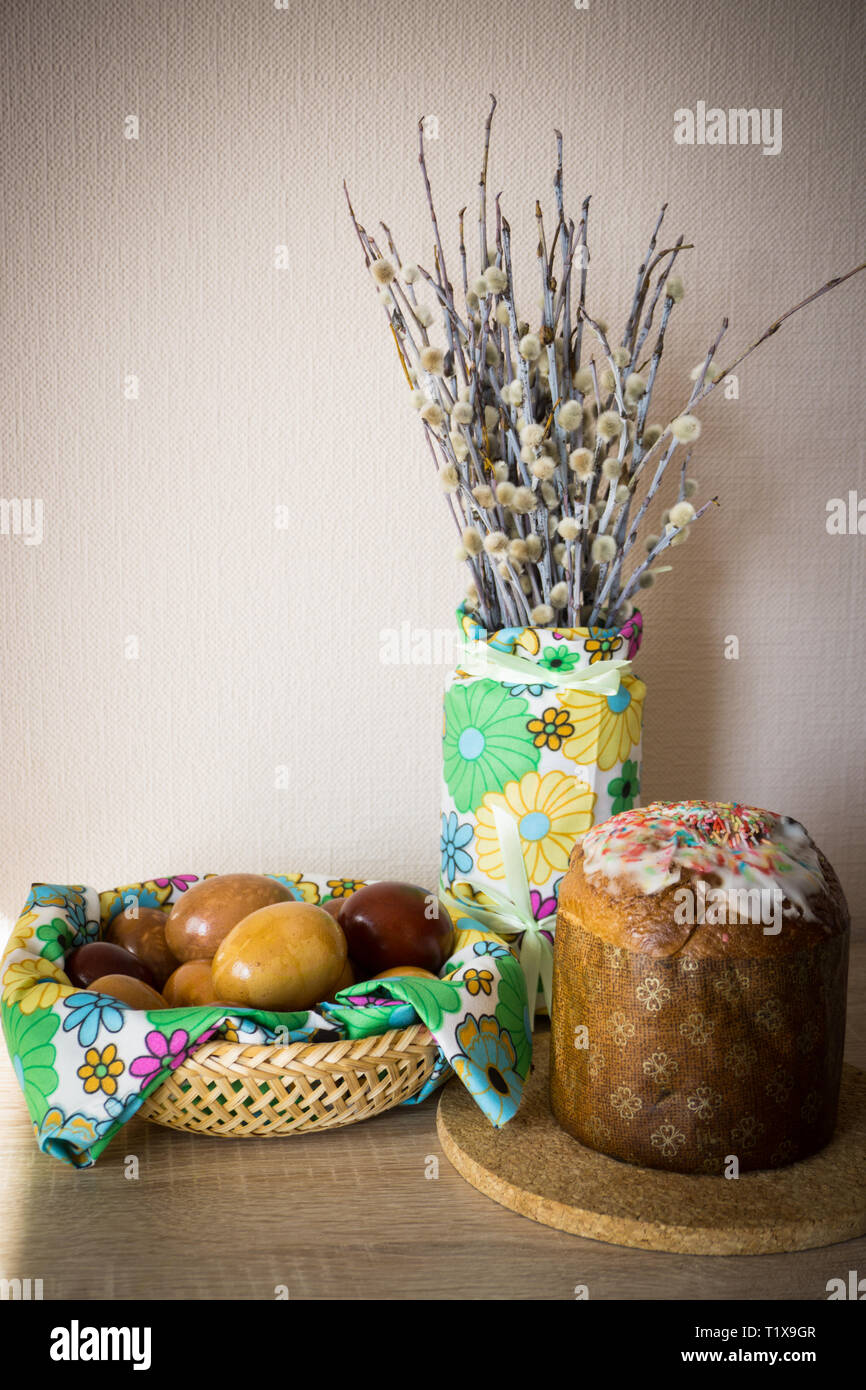 Table before Easter decorated with Easter cake, willow and eggs painted with onion peel Stock Photo