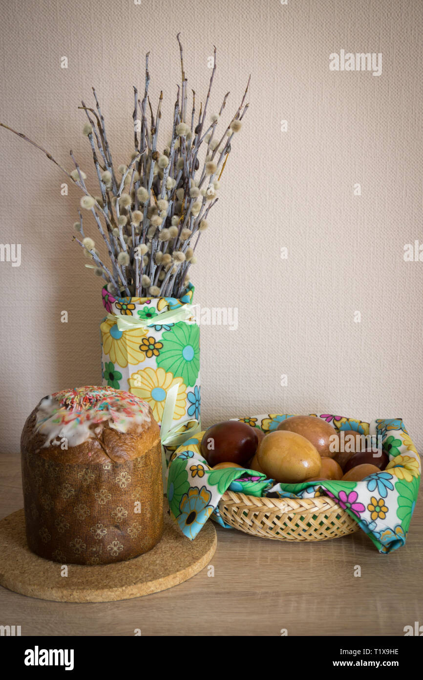 Table before Easter decorated with Easter cake, willow and eggs painted with onion peel Stock Photo