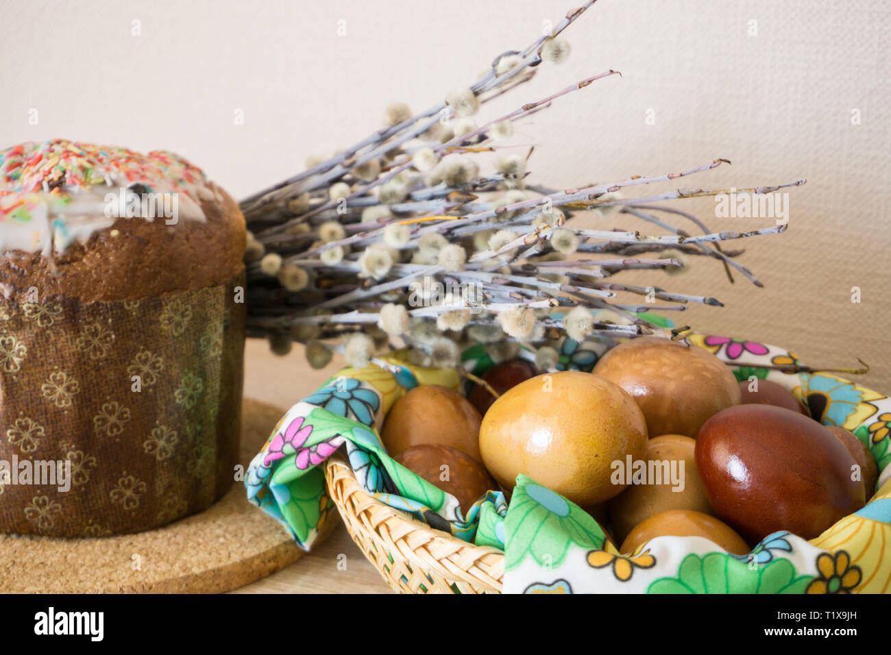 Table before Easter decorated with Easter cake, willow and eggs painted with onion peel Stock Photo