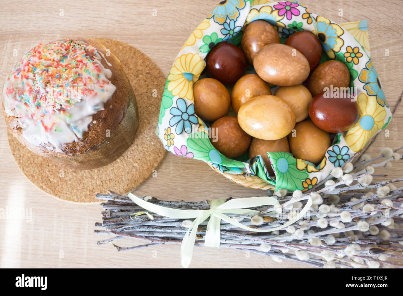 Table before Easter decorated with Easter cake, willow and eggs painted with onion peel Stock Photo