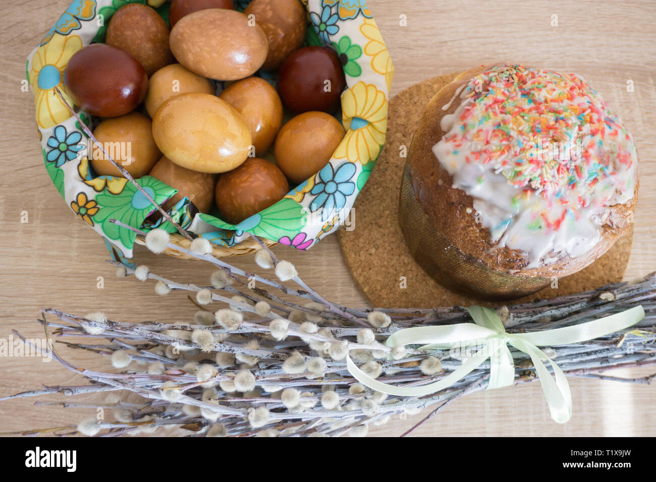 Table before Easter decorated with Easter cake, willow and eggs painted with onion peel Stock Photo