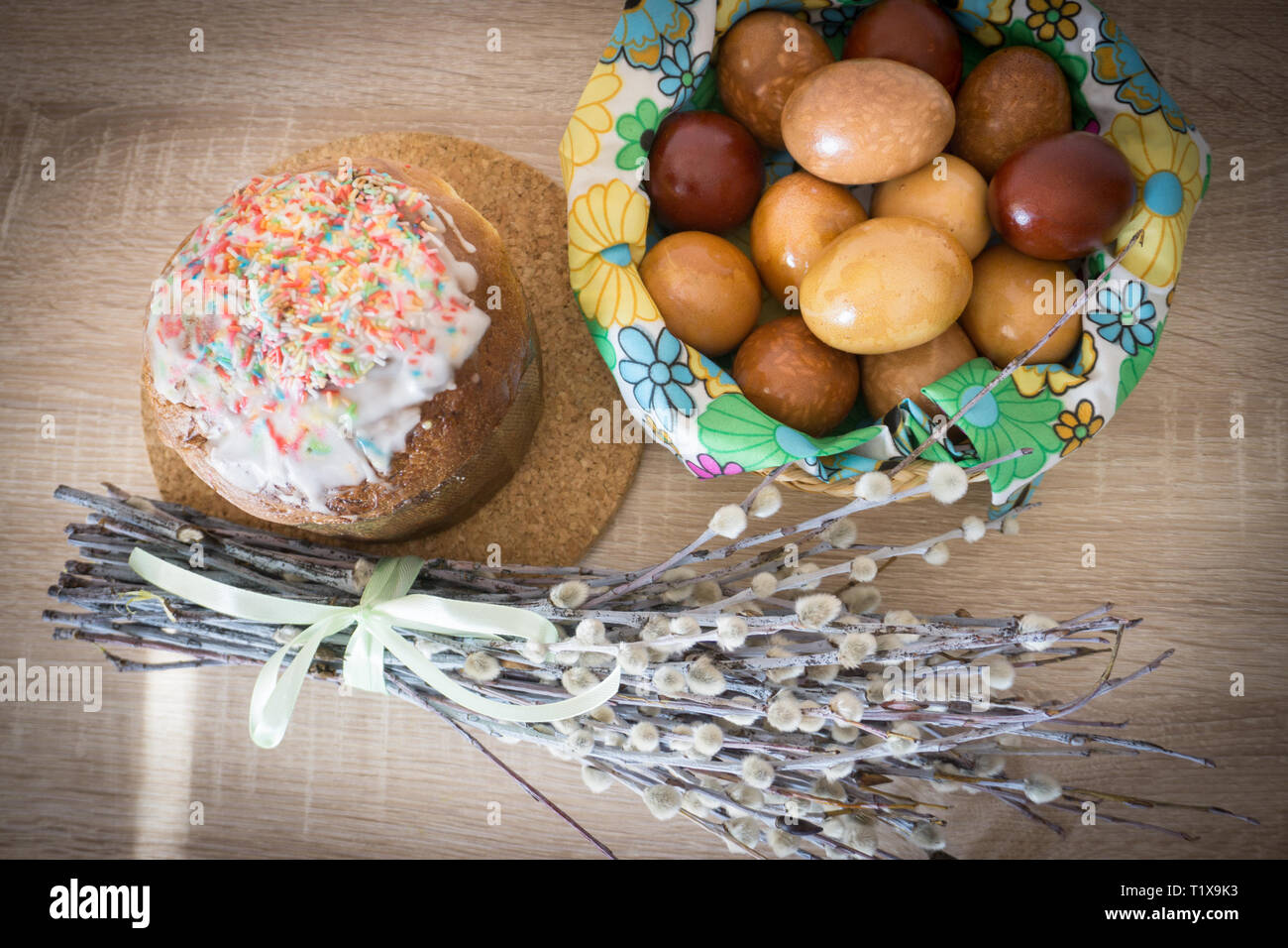 Table before Easter decorated with Easter cake, willow and eggs painted with onion peel Stock Photo