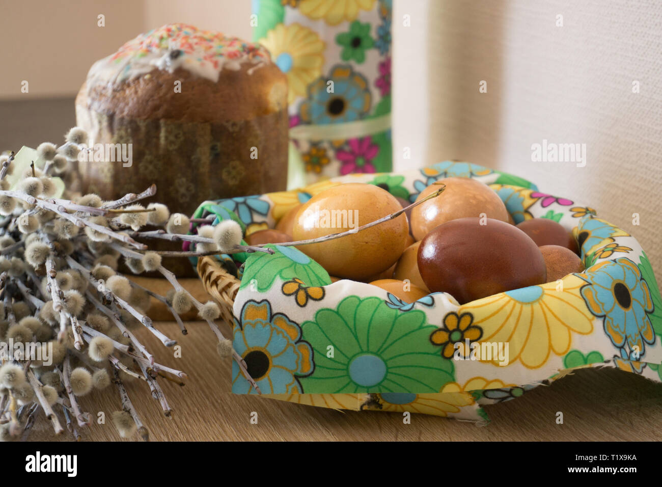 Table before Easter decorated with Easter cake, willow and eggs painted with onion peel Stock Photo
