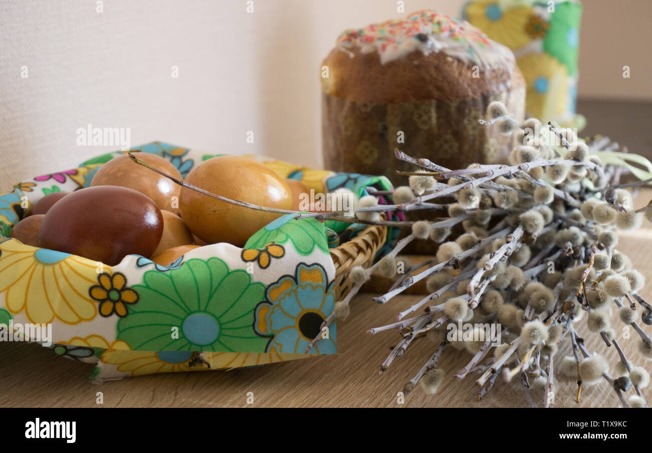 Table before Easter decorated with Easter cake, willow and eggs painted with onion peel Stock Photo