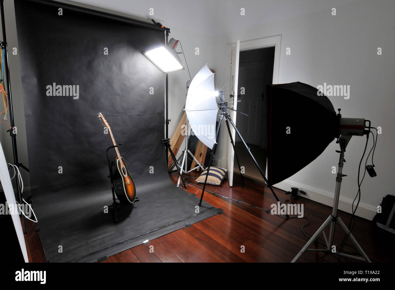 Studio photography setup, with flash lights and soft boxes. An Ovation round back guitar acts as the subject set against a black backdrop. Stock Photo