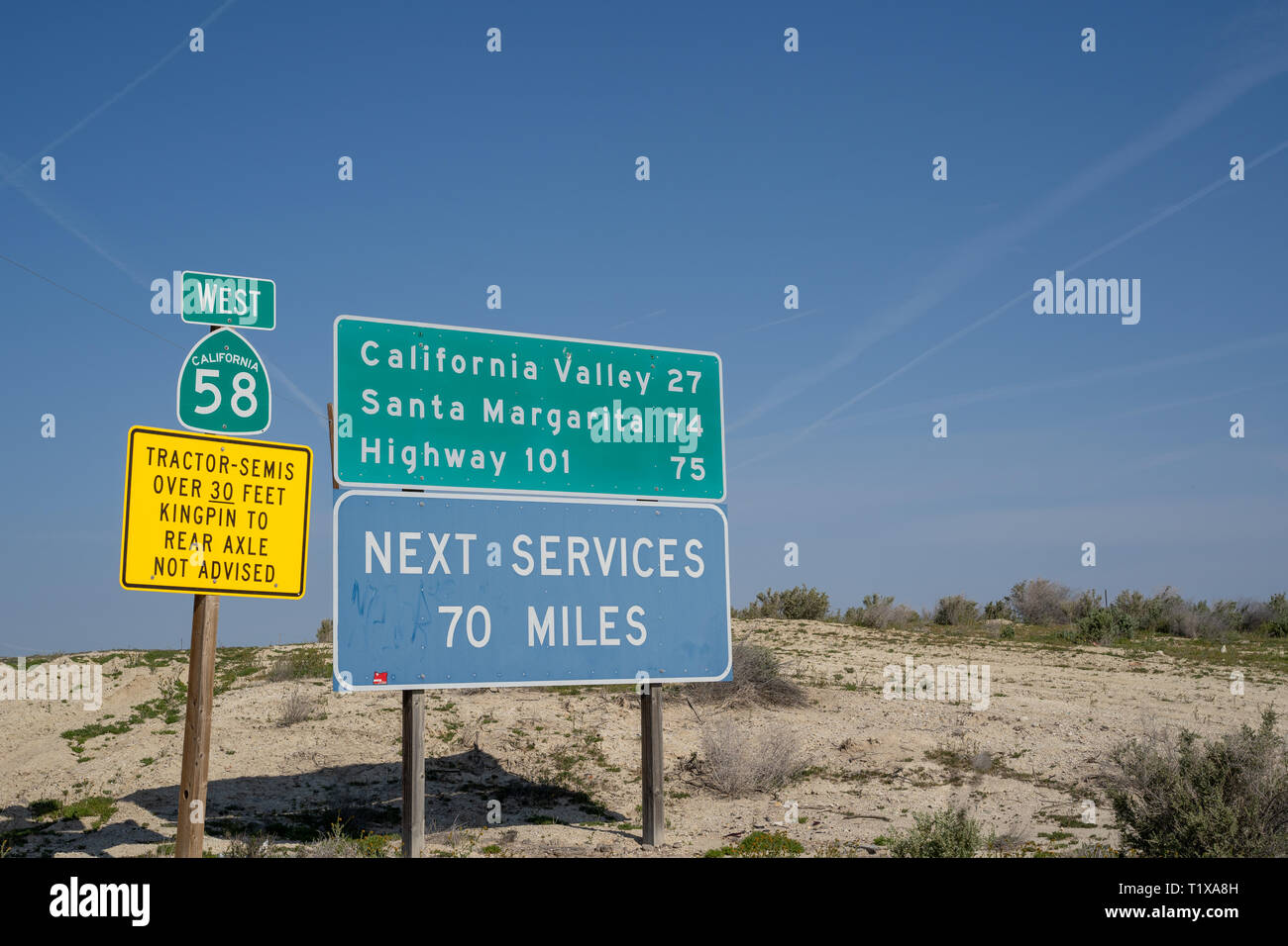 Taft, California - March 25, 2019: Road signs warn drivers of desolate conditions - next services 70 miles, no tractors or semis, on California State  Stock Photo
