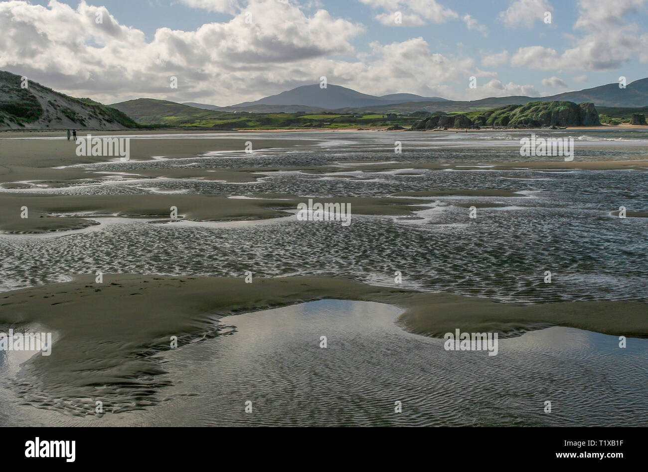 Low tide ripples and sand on the Five Fingers Strand with two people