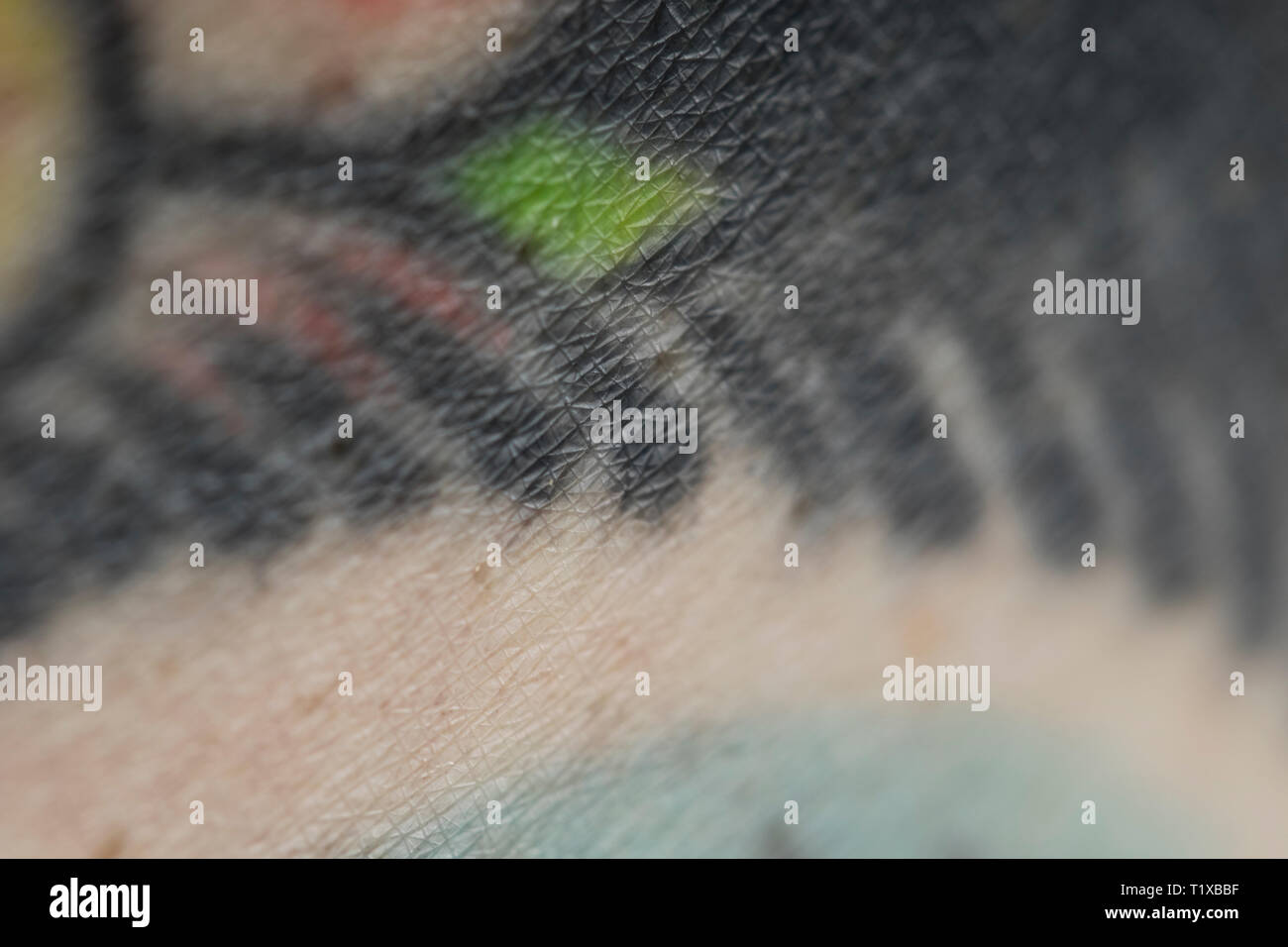 Tattooed skin close up. Pigmented skin cells. Close up of tattoo on skin. Stock Photo