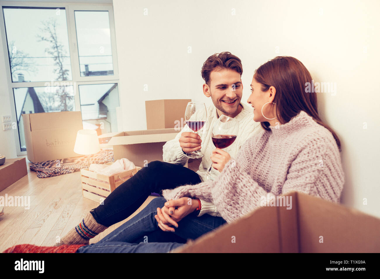 Loving husband holding hand of his wife tight while drinking wine Stock Photo
