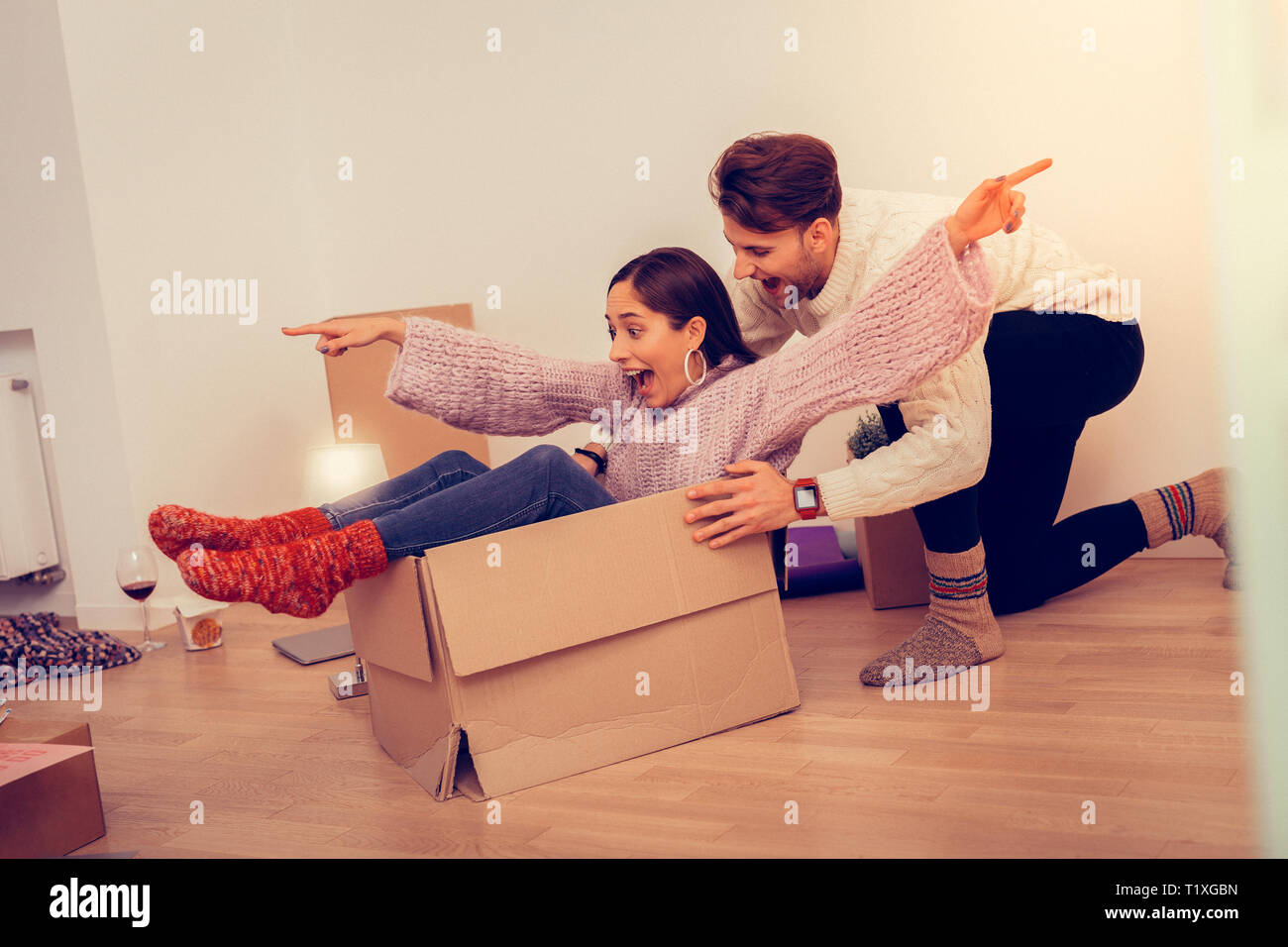 Couple having much fun after unpacking boxes with their clothes Stock ...