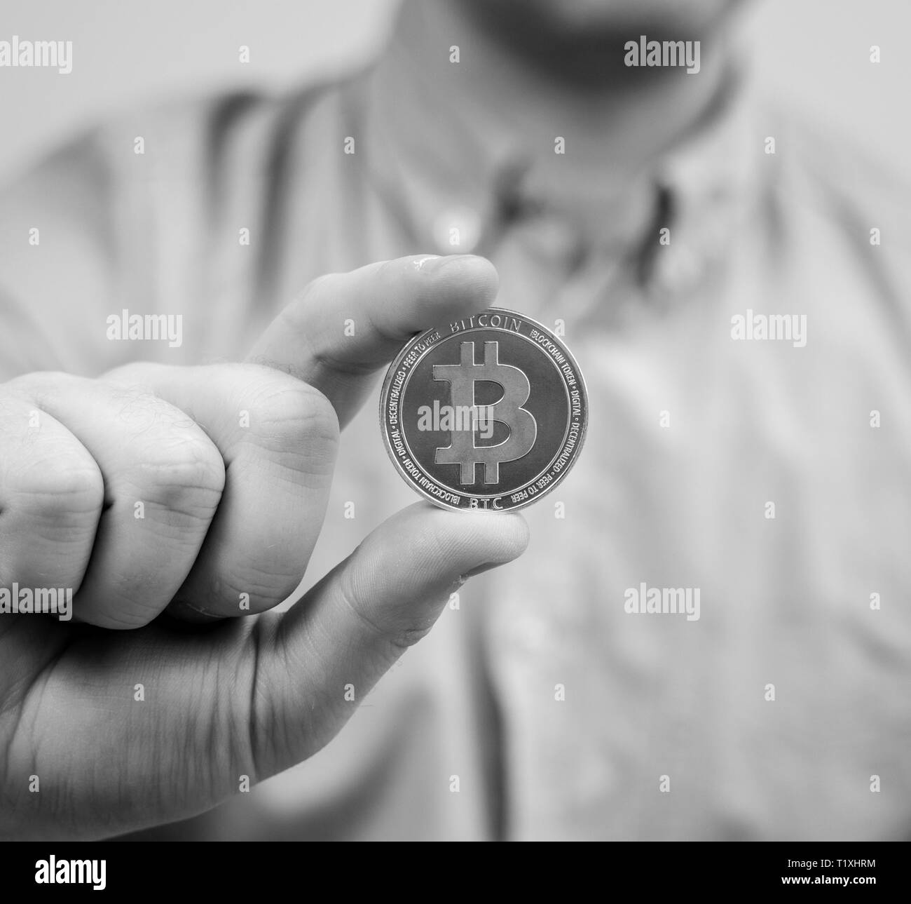 Man holding physical bitcoin. Symbol of virtual currency. Stock Photo