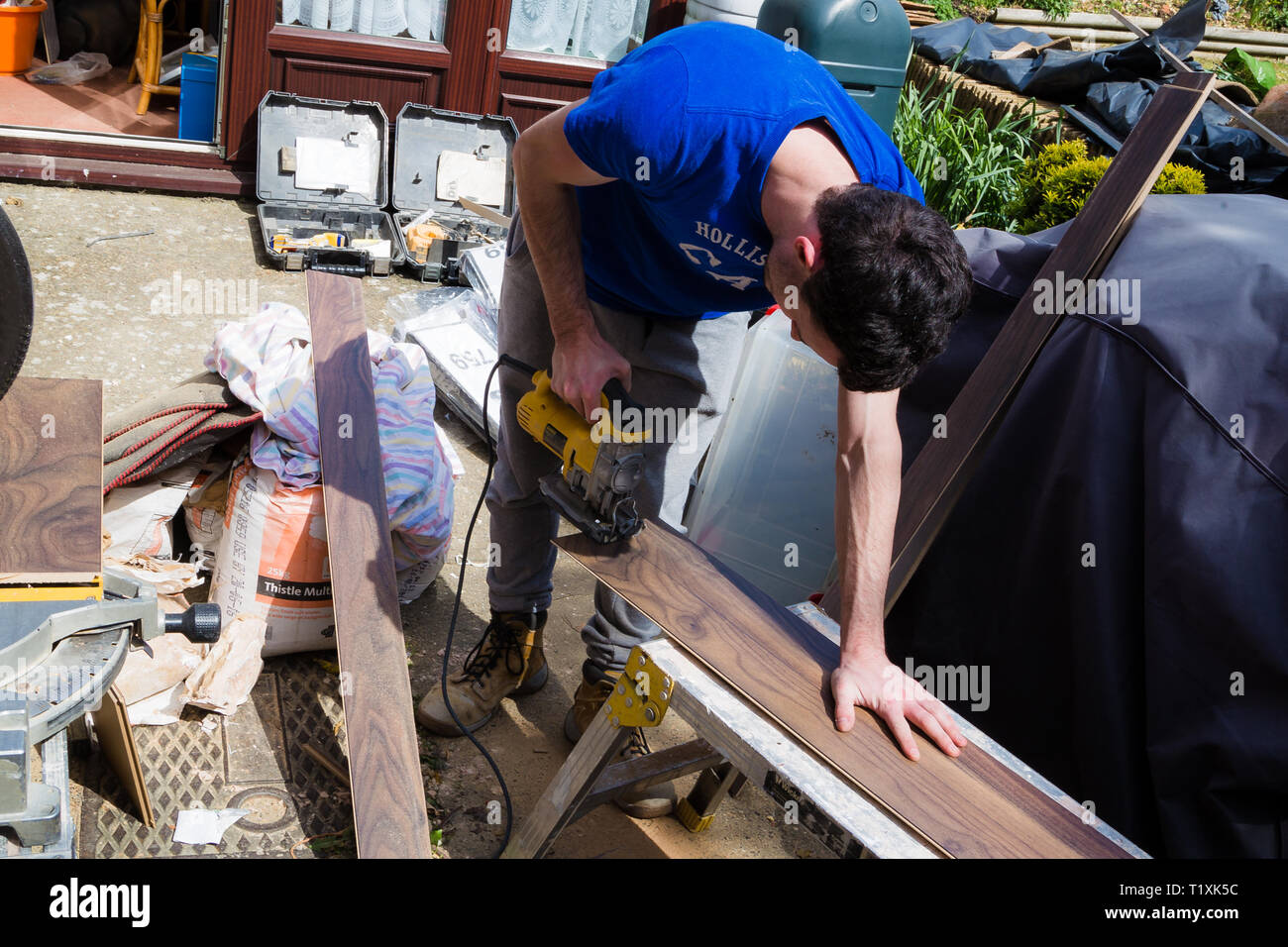 A carpenter at work using power tools and not wearing the appropriate