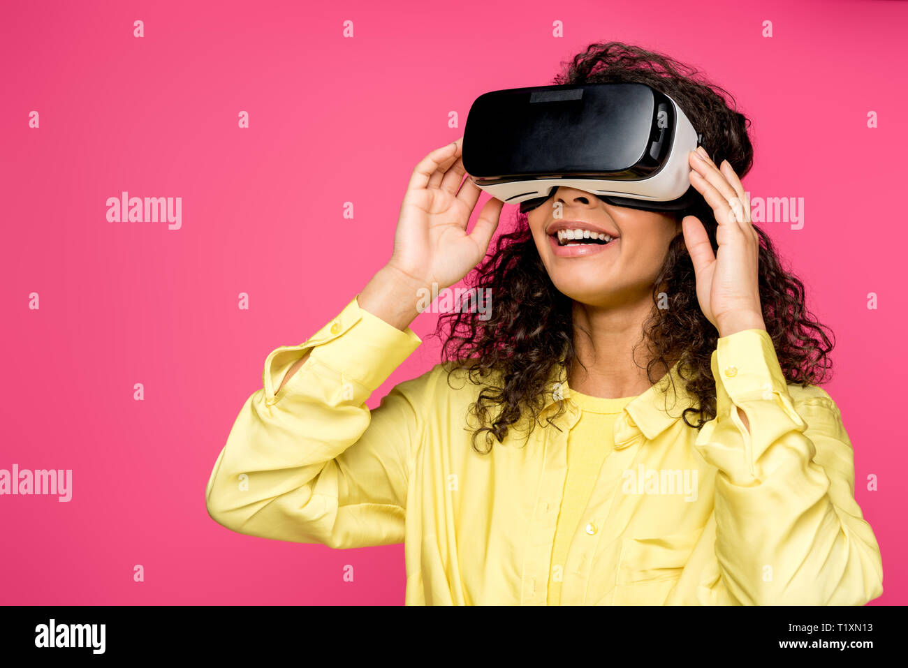 cheerful african american woman wearing virtual reality headset isolated on crimson Stock Photo