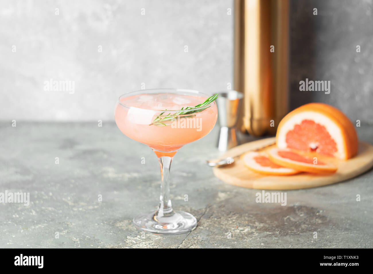 Refreshing summer cocktail of grapefruit rosemary juice and ice in a ...