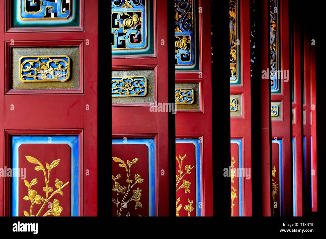 Set of beautiful traditional red, blue and yellow Chinese door panels with rich details and colours in perspective view Stock Photo