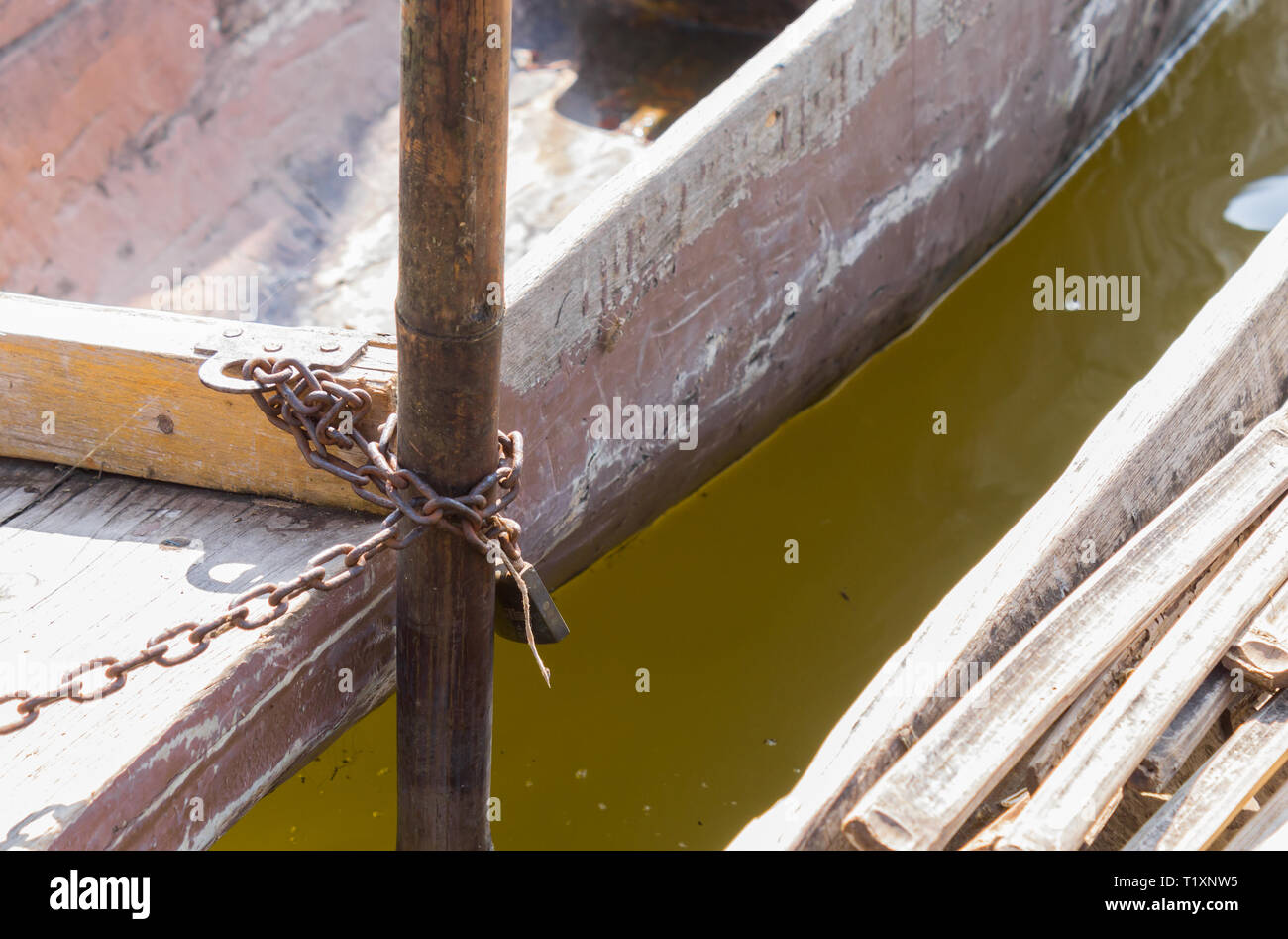 Wood Fishing Boat is Enchained by Iron Chain with Wood Boat Pole. Wood