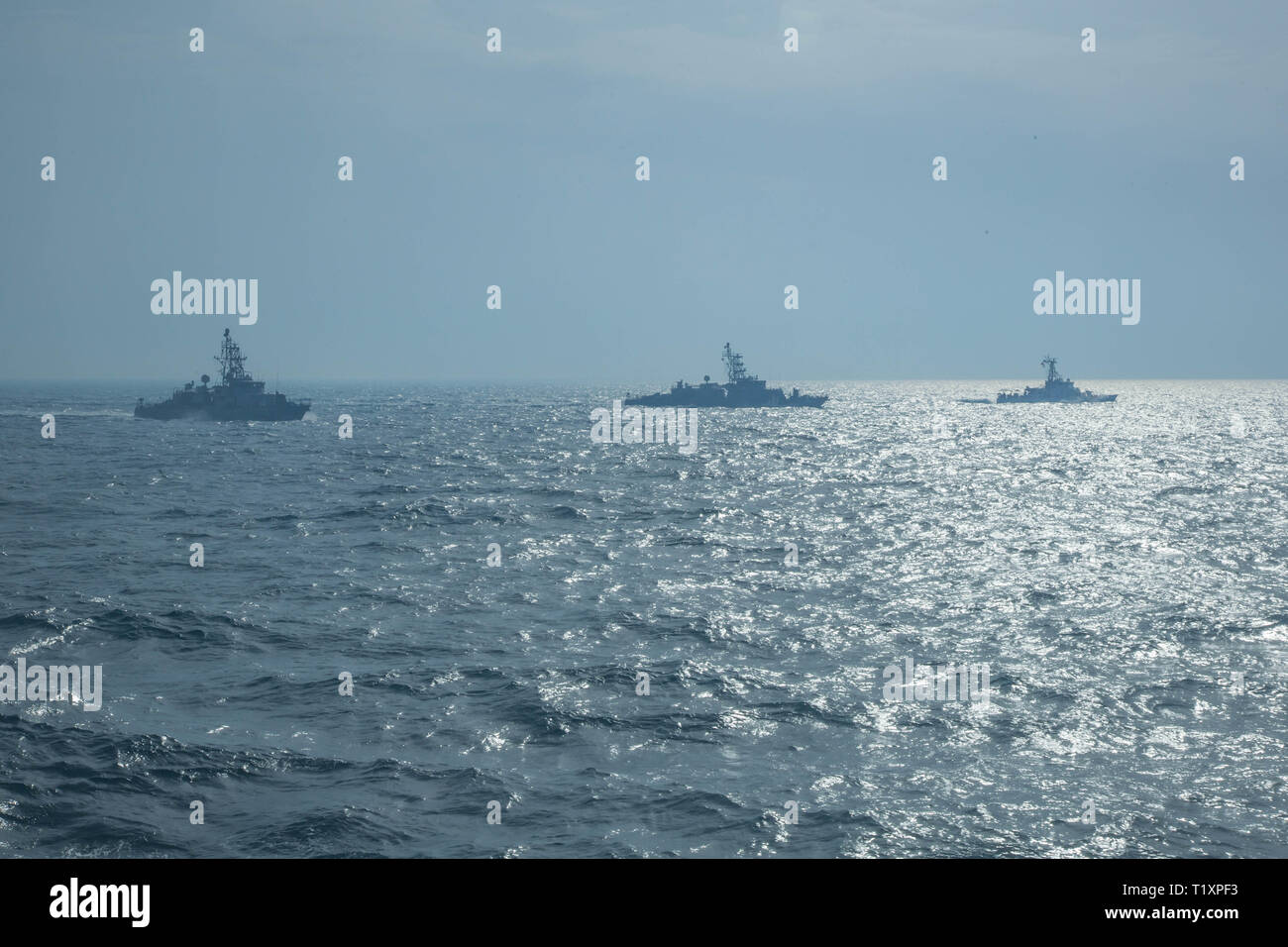 ARABIAN GULF (March 22, 2019) The Cyclone-class coastal patrol ships USS Thunderbolt (PC 12), left, USS Whirlwind (PC 11), center, and the Island-class patrol boat USCGC Aquidneck (WPB 1309) navigate through the Arabian gulf. The Chinook is forward-deployed to the U.S. 5th Fleet area of operations to ensure maritime stability and security in the Central Region, connecting the Mediterranean and Pacific through the western Indian Ocean and three strategic choke points. (U.S. Army photo by Spc. Dakota Young/ Released) Stock Photo