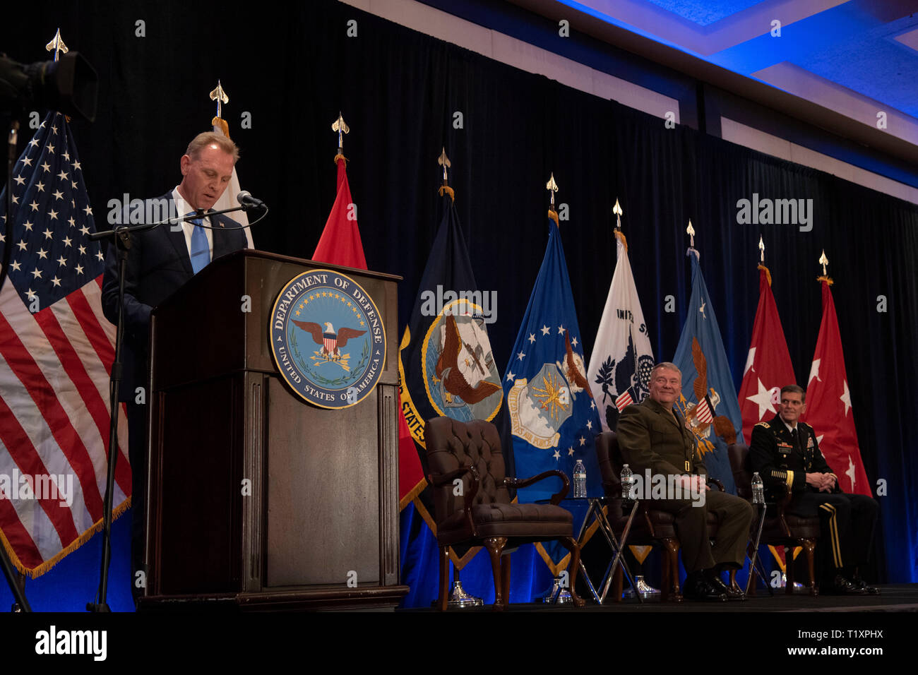 U.S. Acting Secretary of Defense Patrick M. Shanahan speaks at the U.S. Central Command change of command, Tampa, Florida, March 28, 2019. Seated are (center) the new commander of U.S. Central Command, U.S. Marine Corps Gen. Kenneth F. McKenzie Jr., and the outgoing Centcom commander, U.S. Army Gen. Joseph L. Votel. (DoD photo by Lisa Ferdinando) Stock Photo