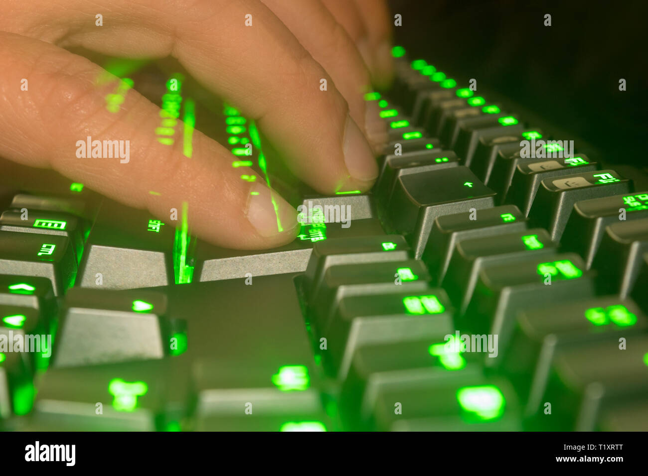 Typing fast on a green keyboard. Concept of hacking. Slow shutter speed. Stock Photo