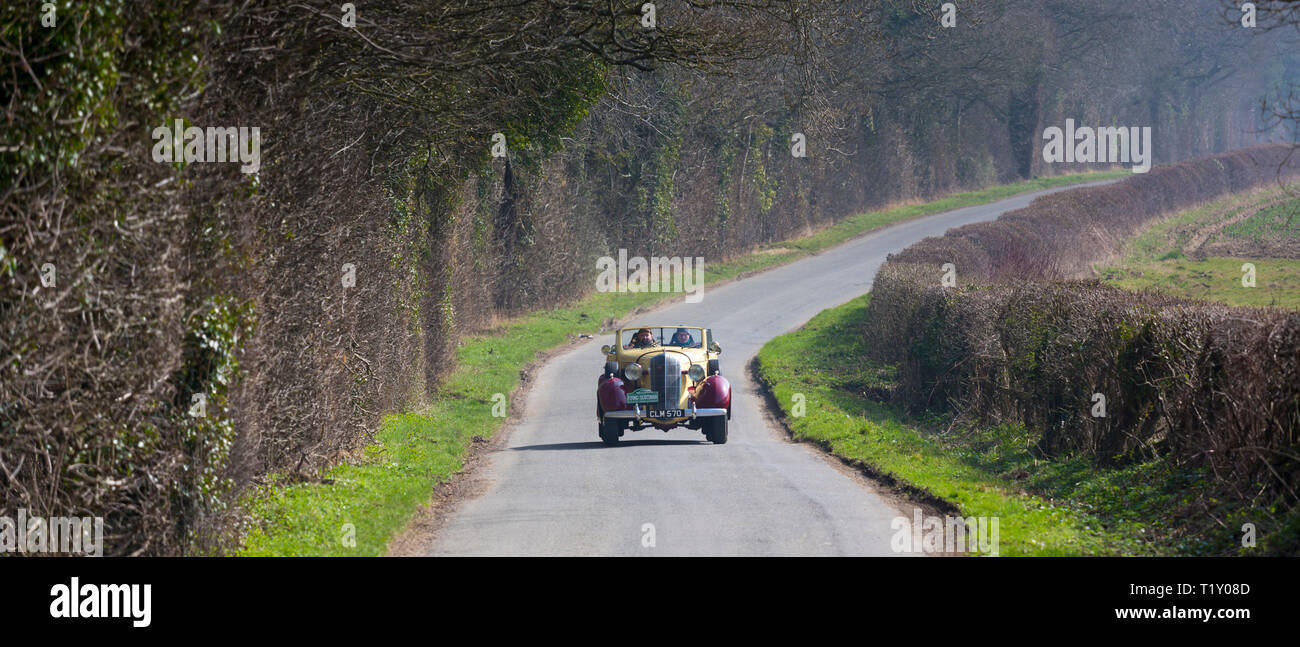Old classic 1936 Buick 40c open top vintageant convertible car driving through country lanes in the Cotswolds, Oxfordshire. UK Stock Photo