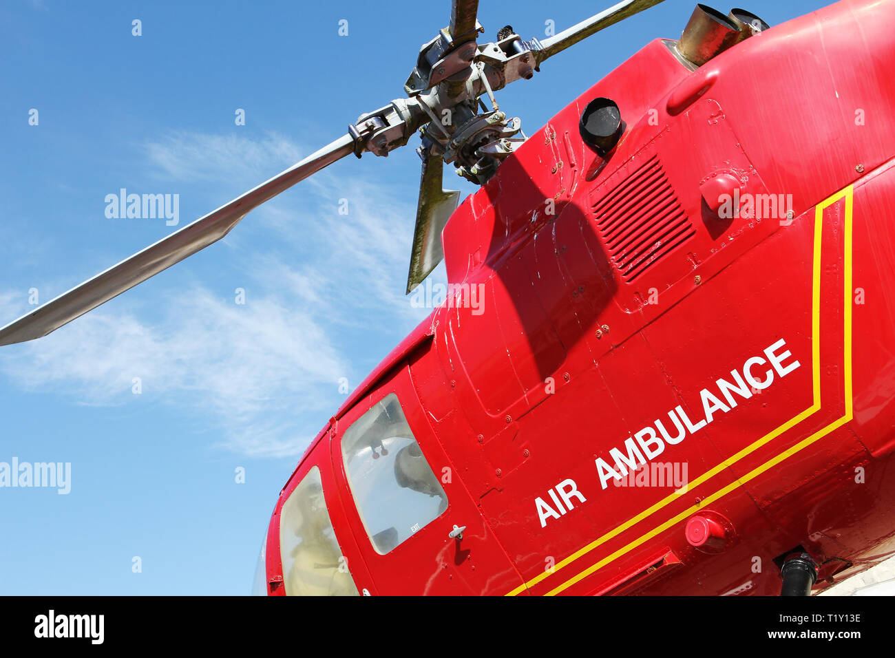 Red helicopter of air ambulance isolated on blue sky background. Detail