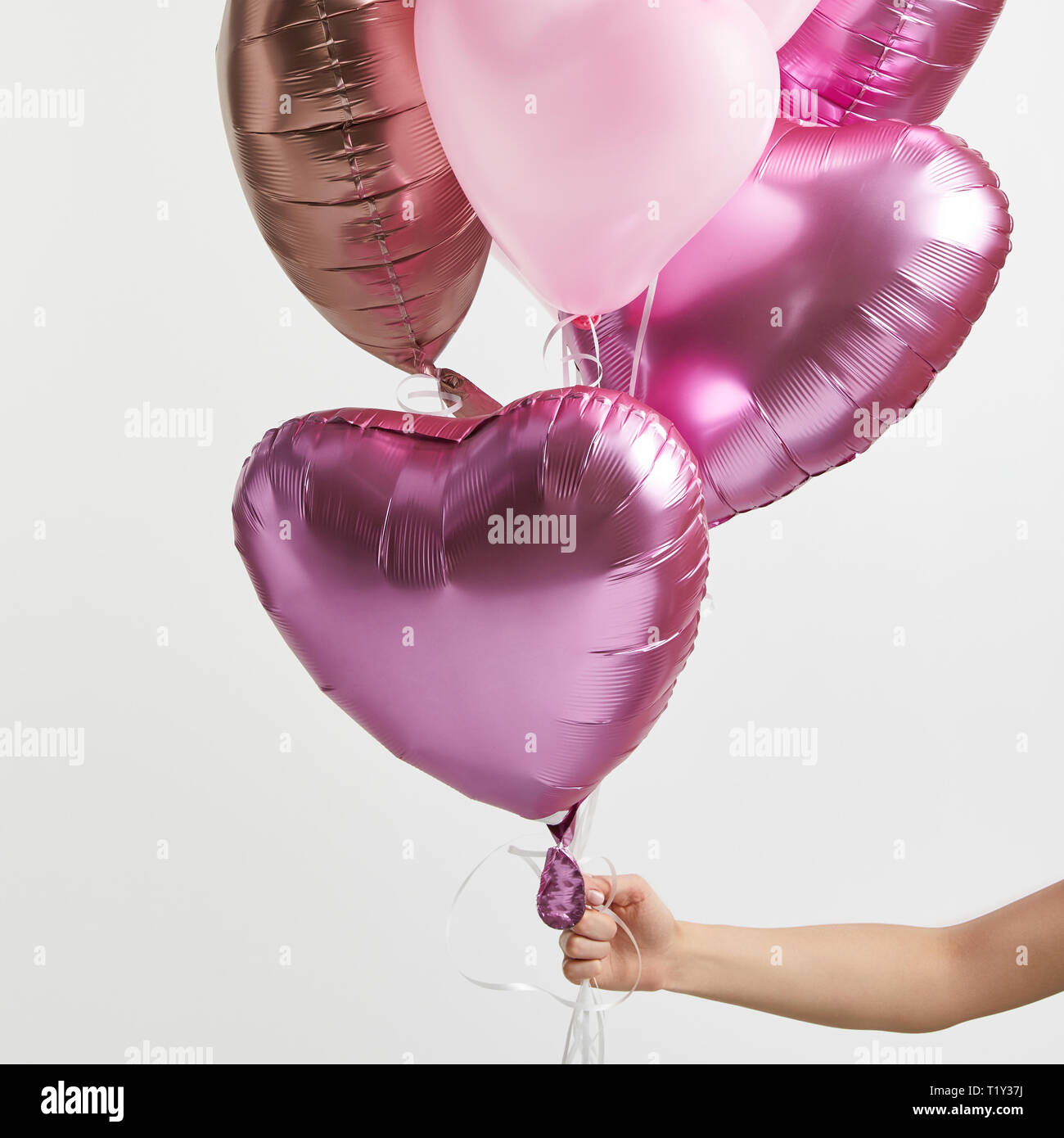 Woman holding heart pink balloons hi-res stock photography and images ...
