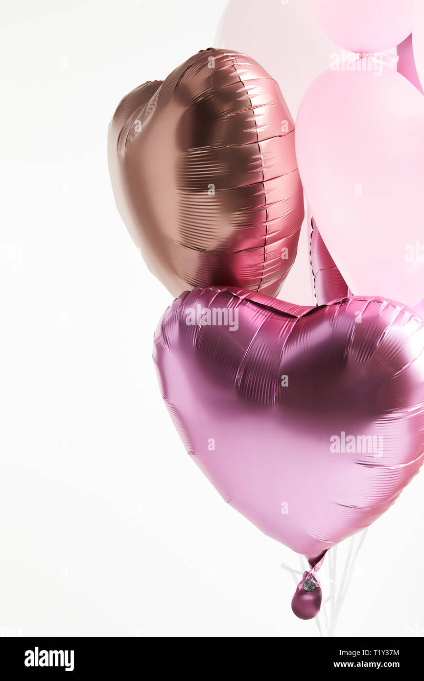 heart-shaped pink and golden festive air balloons isolated on white Stock Photo