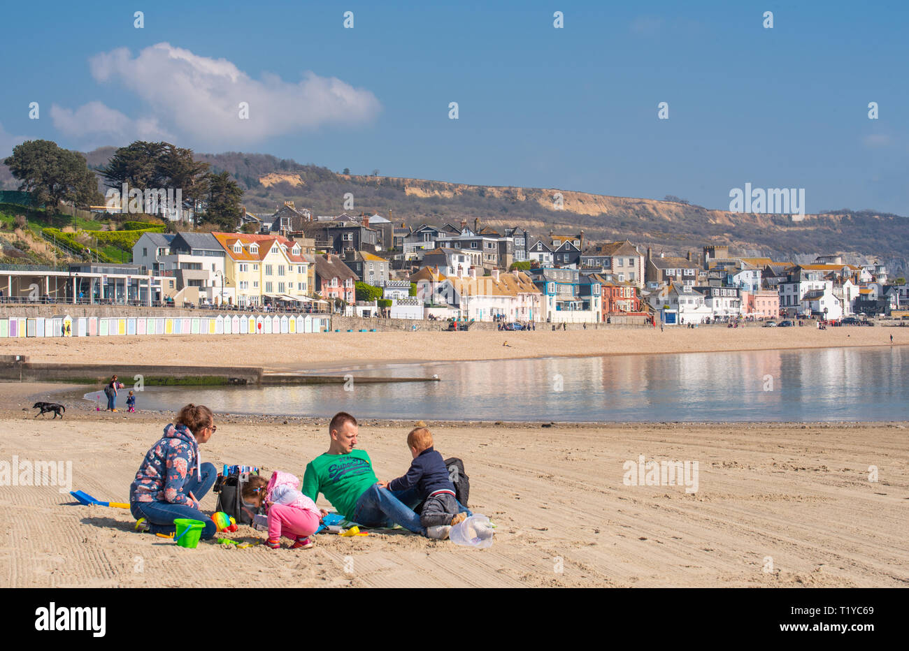 Lyme Regis, Dorset, UK. 29th March 2019. UK Weather: Another day of glorious sunshine and bright blue skies as the seaside resort town of Lyme Regis as the early spring heatwave continues.  Visitors and families enjoy the unseasonably hot weather on the sandy beach. Credit: Celia McMahon/Alamy Live News Stock Photo