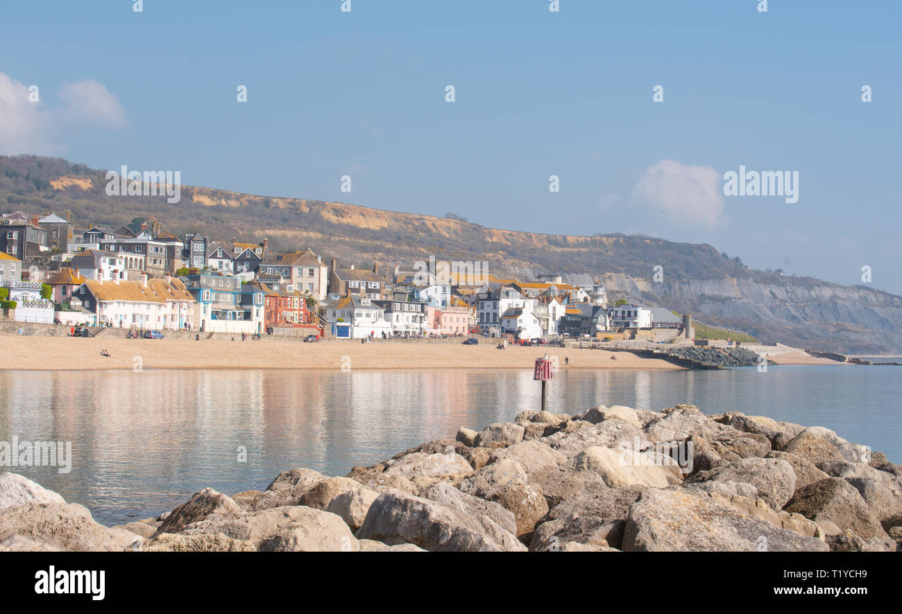 Lyme Regis, Dorset, UK. 29th March 2019. UK Weather: Another day of glorious sunshine and bright blue skies as the seaside resort town of Lyme Regis as the early spring heatwave continues. The picturesque buildings are reflected in the calm water. Credit: Celia McMahon/Alamy Live News Stock Photo