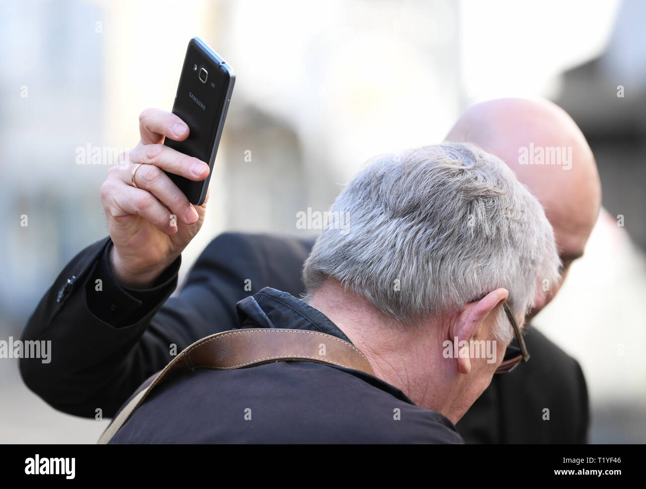 Wiesbaden, Germany. 29th Mar, 2019. Pickpocket and trick thief artist Giovanni Alecci (in the back) takes the mobile phone of a pedestrian in the Wiesbaden pedestrian zone unnoticed during the police security day. The police in Hesse want to fight street crime and work with the tricks of thieves. Actions and information stands are designed to improve citizens' sense of security. Credit: Arne Dedert/dpa/Alamy Live News Stock Photo