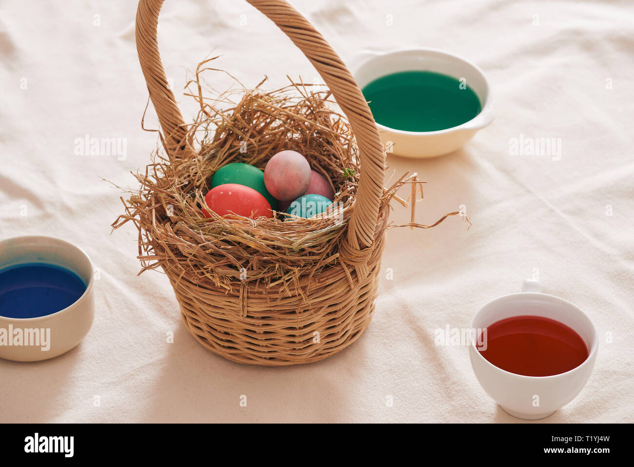 Beautiful Easter composition with multicolored eggs and flowers on linen background Stock Photo