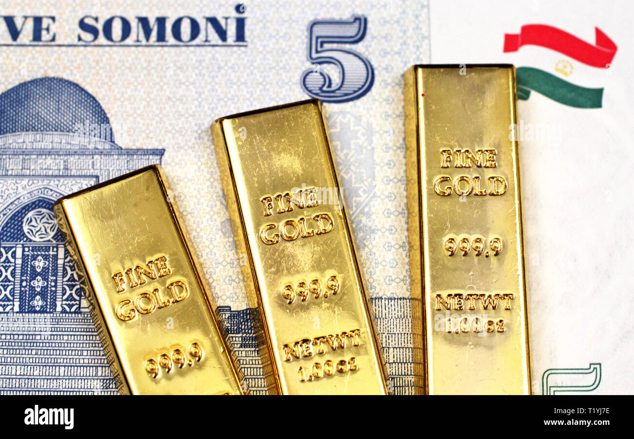 A close up image of a Tajikistan five somoni bill with three golden ingots in macro Stock Photo