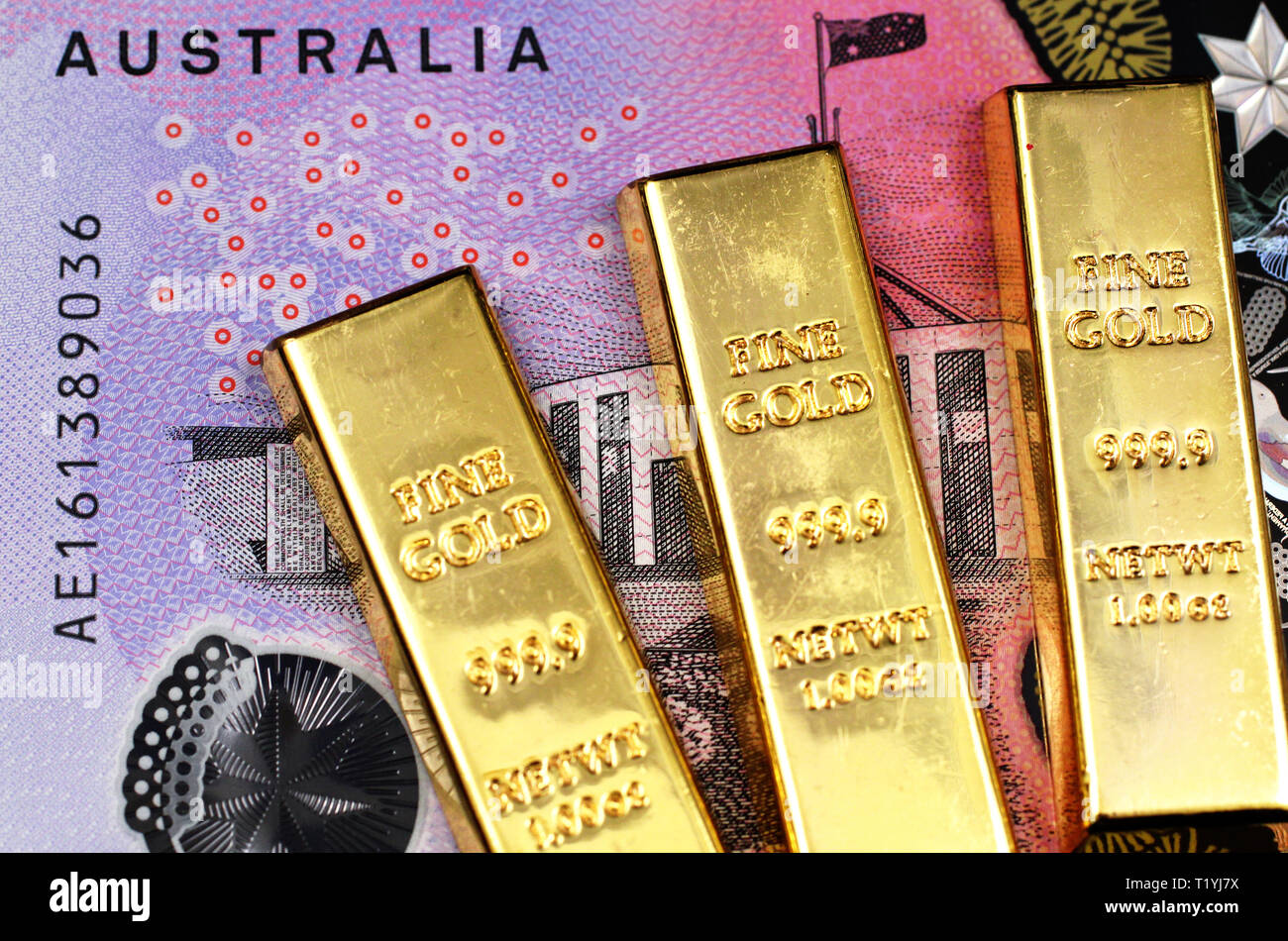A close up image of three gold bars in macro with an Australian five