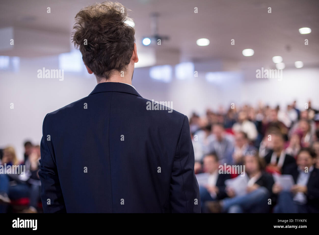 rear view of young successful businessman at business conference room ...