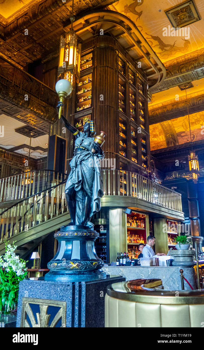 Bronze sculpture by tall cabinet or gin tower the centerpiece of the Atlas bar in the lobby of Parkview Square Singapore. Stock Photo