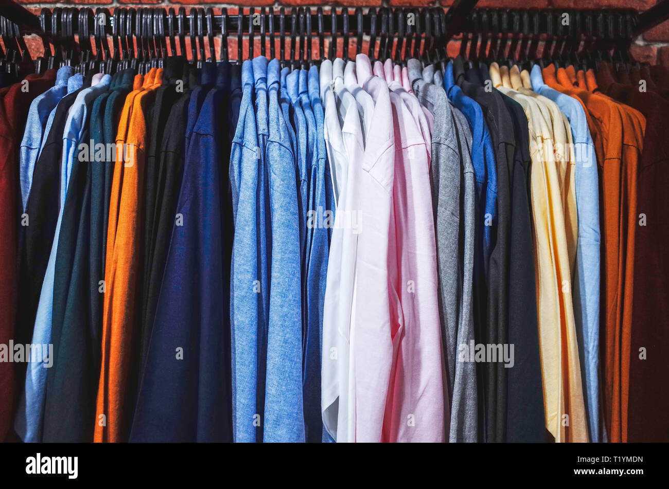 Multi colored clothing hanging on hangers Stock Photo Alamy
